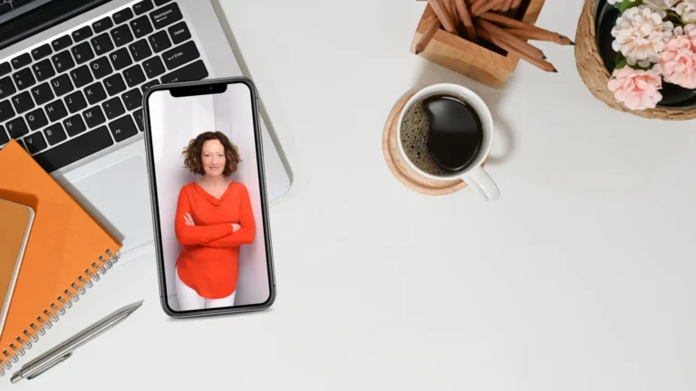 Flatlay - Smartphone mit Bild von Claudia, Laptop, Kaffeetasse